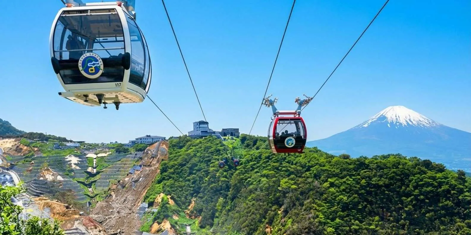Ropeway cabins crossing volcanic terrain