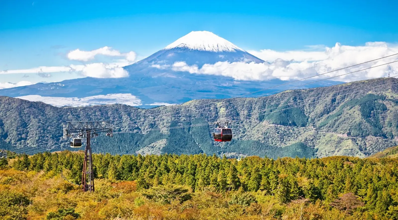Ropeway cabins with Mount Fuji beyond the valley